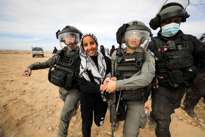 Israëlische troepen pakken een Bedoeïense vrouw op.