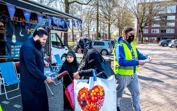 De Ramadan Tour van Moslim Empowerment Tilburg (MET) op het Verdiplein. Een van de organisatoren Mohamed El Hani (links) bespreekt de Ramadan-problemen met bezoekers van de Ramadan-bus. Rechts Mohammed Aknin van MET.