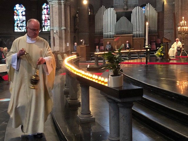Pastoor John van de Laar bewierookt de net aangestoken kaarsen tijdens de viering van Allerzielen.