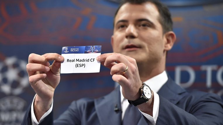 Oud-voetballer Dejan Stankovic toont het papiertje met de naam van Real Madrid tijdens de loting, vrijdag. Beeld afp