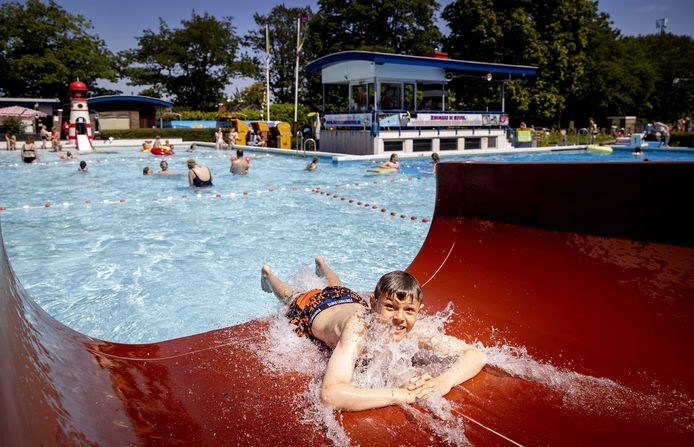 Zwemmers zoeken verkoeling in een openluchtzwembad tijdens een van de tropisch warme dagen in juni dit jaar.