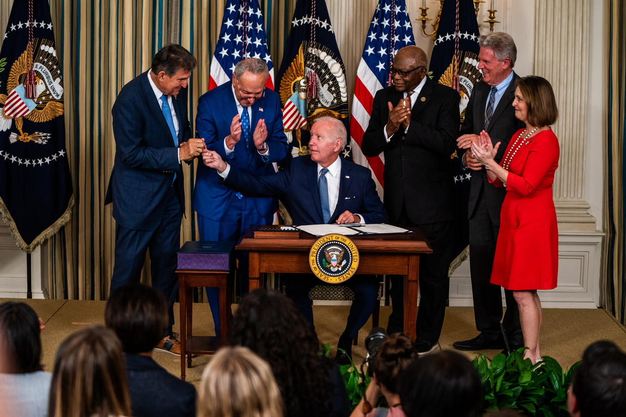 President Joe Biden overhandigt de pen waarmee hij in augustus de Inflation Reduction Act 2022 heeft ondertekend aan senator Joe Manchin. Dit is een afgeslankte versie van Bidens oorspronkelijke Build Back Better Act, waartegen Manchin zich verzette. 
 Beeld Demetrius Freeman / Getty