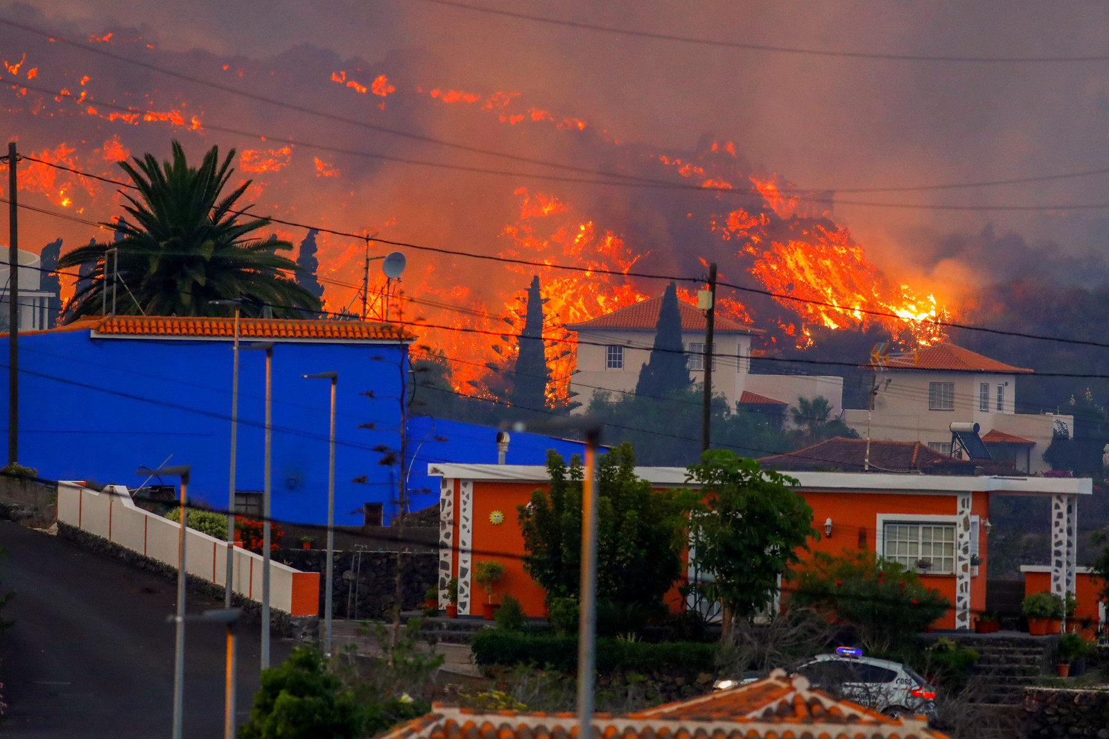 De lava op La Palma nadert maandag een rij huizen bij Los Llanos de Aridane. Volgens vulkaan-expert Rob Govers kan de uitbarsting, die niet heel explosief is, een flinke tijd aanhouden.   Beeld REUTERS
