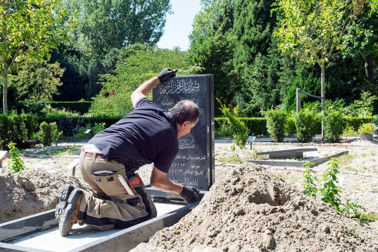 Werknemer Ismail van de firma Natuursteen plaatst een islamitische grafzerk op begraafplaats Crooswijk in Rotterdam.  Beeld  Hans van Rhoon