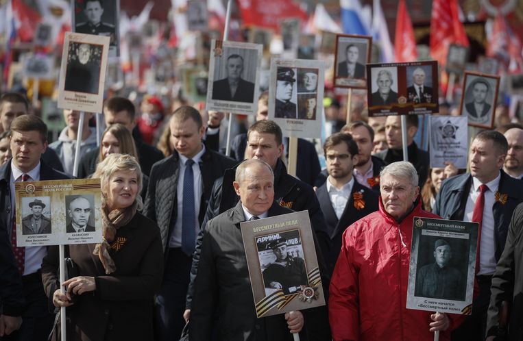 Vladimir Poetin draagt, net als andere Russen, een portret van een familielid dat heeft gevochten in de Tweede Wereldoorlog. Beeld ANP / EPA