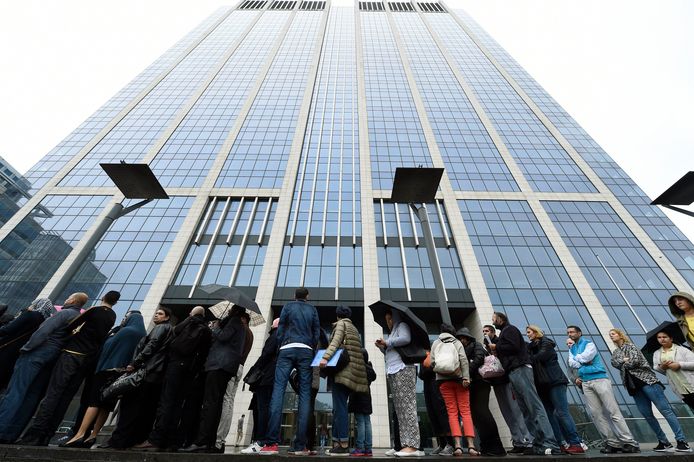 Mensen staan in de rij voor de Finance Tower in Brussel om hulp met hun belastingaangifte te krijgen.