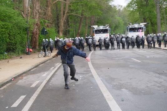 Een manifestant gooit met een steen richting politie. Heel wat straatmeubilair moet er aan geloven.