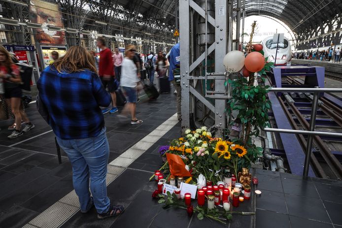 Bloemen, kaarsjes en handgeschreven steunbetuigingen bij de plaats delict op perron 7 in het station van Frankfurt.