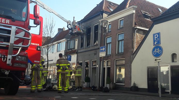 Brandweerlieden zijn de hele maandag nog bezig met nablussen van de compleet verwoeste woning aan de Laarstraat in Zutphen.