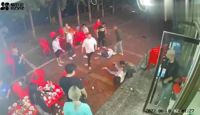Twee vrouwen liggen op de grond nadat ze zijn mishandeld in Tangshan.