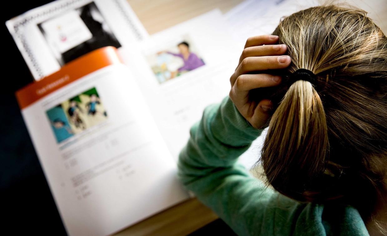 Een leerling van groep 8 buigt zich over een eindtoets. Beeld ANP