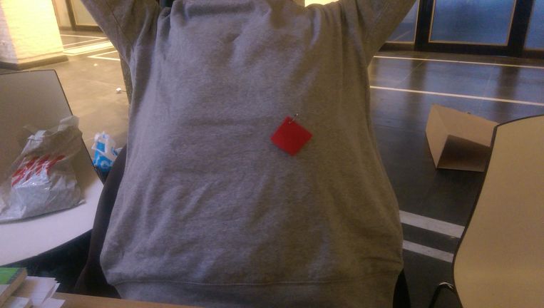 Een rood stukje vilt, opgespeld met een veiligheidsspeld. Beeld Heleen van Lier