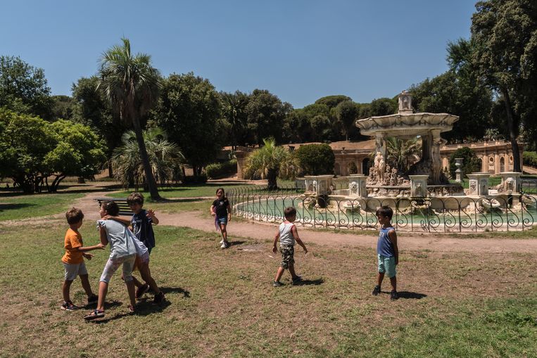 I bambini giocano in un campo estivo a Villa Doria Bambili in un parco romano.  Statua di Nicola Sol