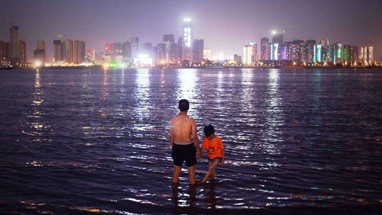 Man en kind staan in de oever van de Yangtze rivier Beeld afp