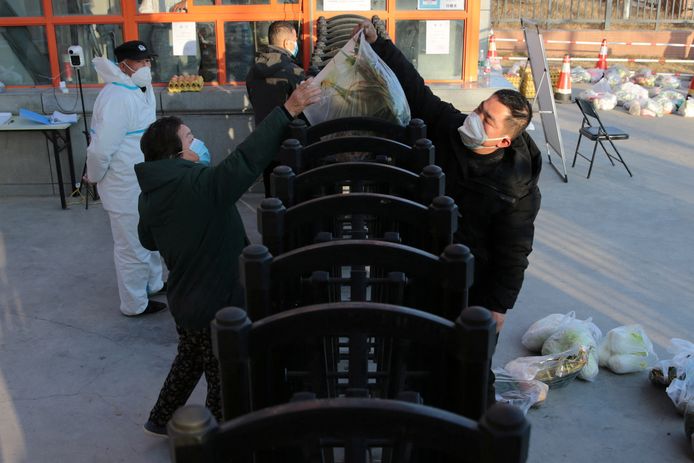 29 december 2021: Een leverancier geeft voeding aan de inwoners van een appartementsgebouw in Xi’an. Het coronabeleid zorgt in verschillende Chinese steden voor chaos. Zo is er niet enkel sprake van uitgestelde zorg, maar zijn er ook groeiende voedseltekorten.