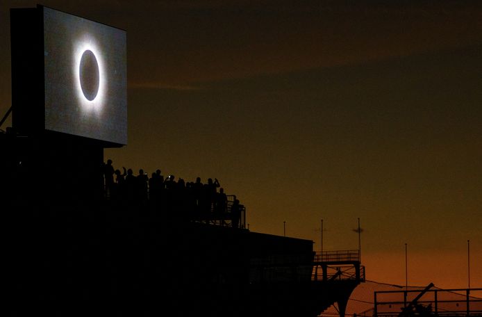 Mensen kijken naar de zonsverduistering op de tribunes van een racecircuit in Indianapolis, Indiana.