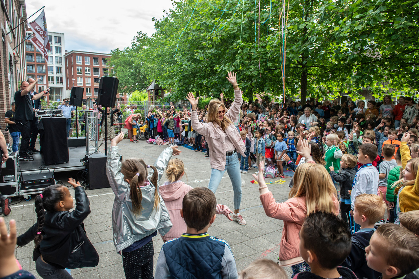 Muziekcoach Jaqueline Heilema van kbs St. Joseph in Breda enthousiasmeert zwaaiend met de handen in de lucht de kinderen ook mee te dansen op de muziek tijdens de opening van de DJ-Dagen op de basisschool.