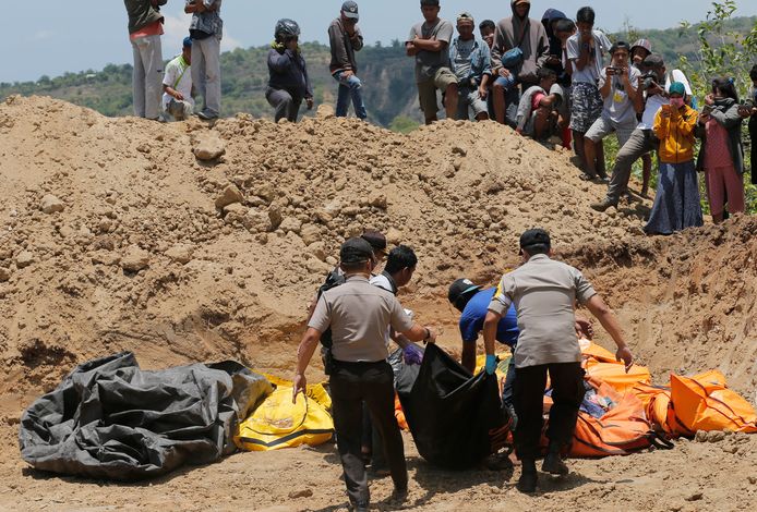 In Palu worden de gevonden lichamen naar een massagraf gebracht.