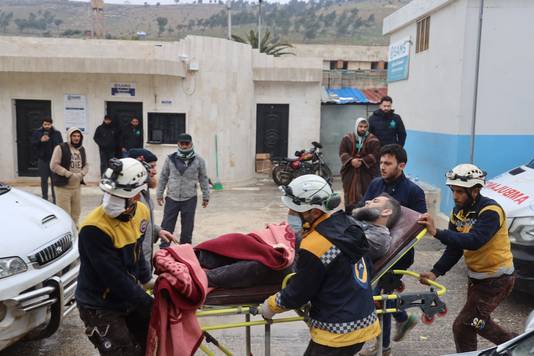 Leden van de Syrische Witte Helmen met een gewonde aan een ziekenhuis nabij de Bab al-Hawa-grensovergang.