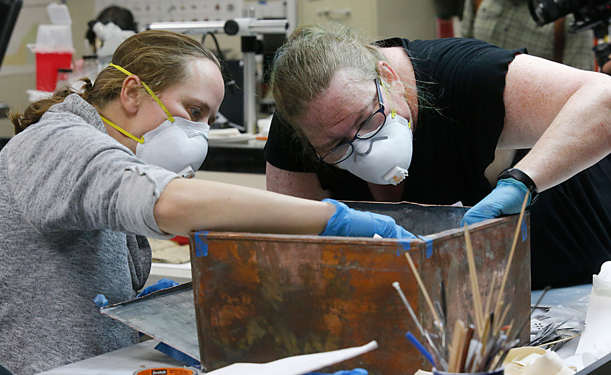Researchers Sue Donovan and Kate Ridgway (right) dig inside a time capsule.  AP . image