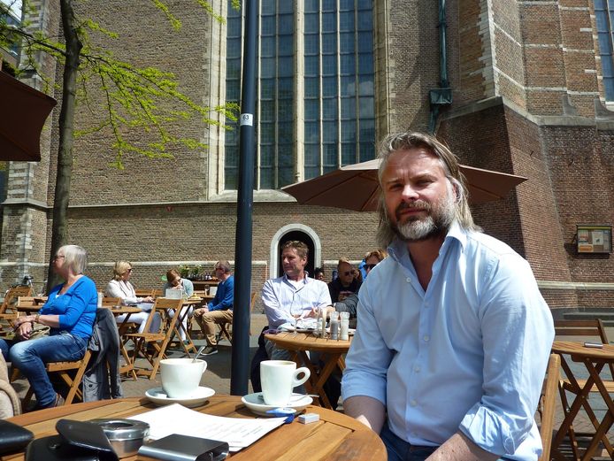 Hans Mosselman, toen de horeca nog open was, op het terras van De Swarte Leeuw bij de Laurenskerk in Rotterdam.
