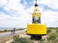 De nieuwe boei op de dijk vlakbij de vuurtoren. Links Adrie Janssen die mee heeft geholpen met het schilderen van de boei.