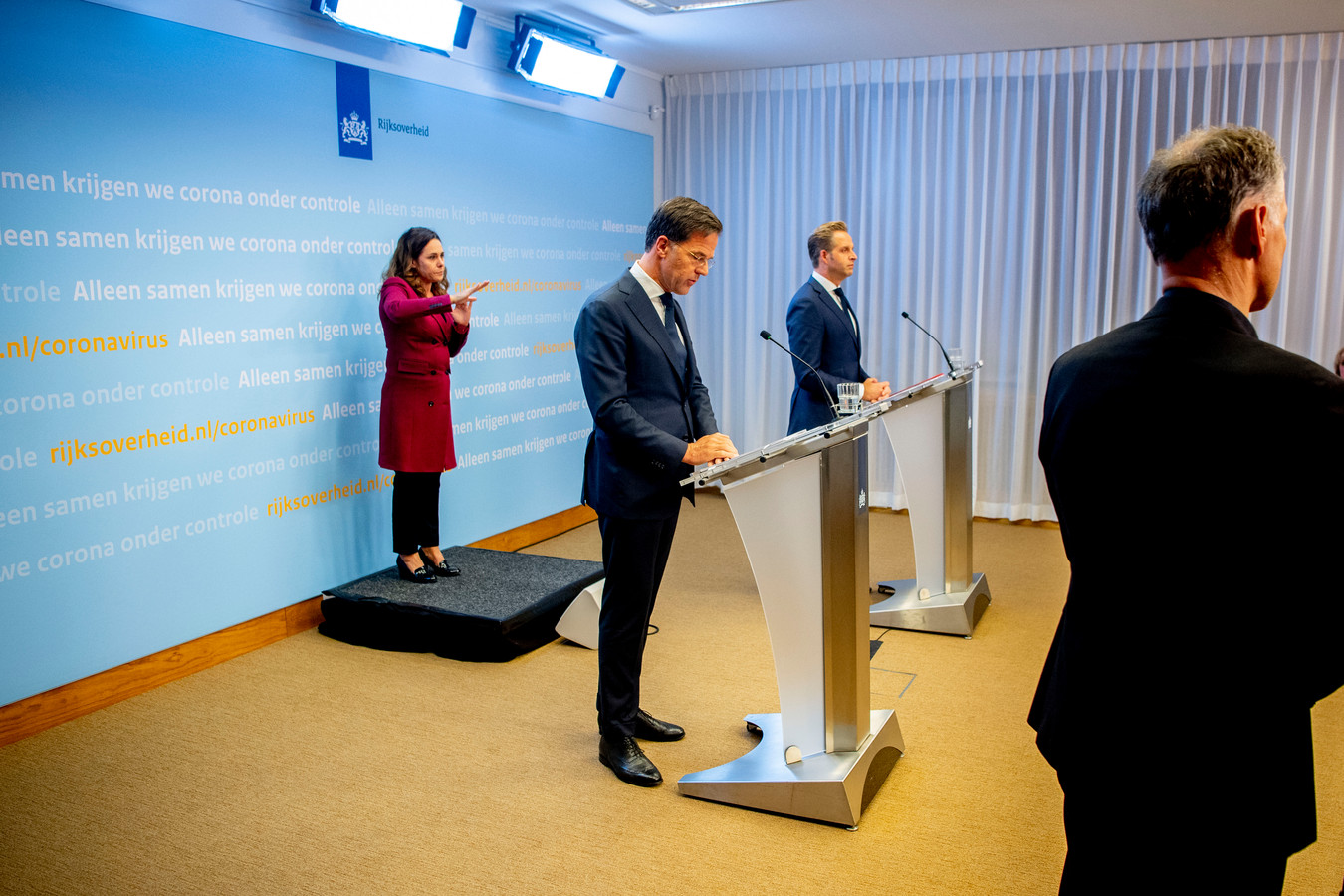 Premier Mark Rutte, minister Hugo de Jonge van Volksgezondheid, Welzijn en Sport en gebarentolk Irma Sluis bij de laatste persconferentie in Den Haag.