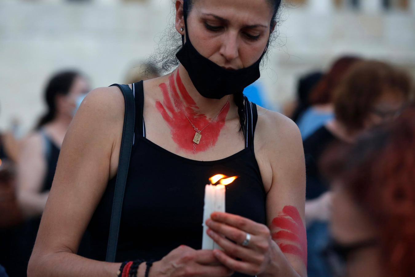 Une femme tient une bougie lors d'une manifestation sur la place Syntagma, dans le centre d'Athènes, en Grèce, le 19 juin 2021, à la mémoire de Caroline Crouch, une jeune femme de 20 ans qui a été assassinée par son mari le 11 mai.