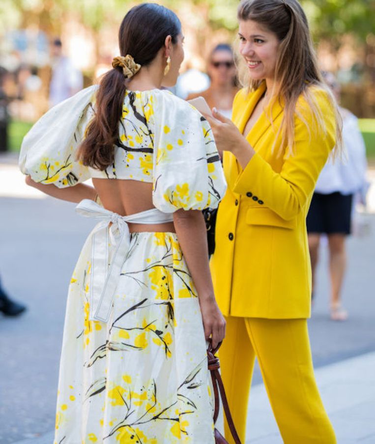 LONDON, ENGLAND - SEPTEMBER 14: Bettina Looney is seen wearing yellow white dress with graphic print, brown bag and a guest wearing yellow suit outside Ports 1961 during London Fashion Week September 2019 on September 14, 2019 in London, England. (Photo by Christian Vierig/Getty Images) Beeld Getty Images