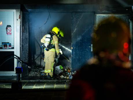 Brand in inpandige afvalcontainer bij flat, brandweer moest zich door rommel heen banen 