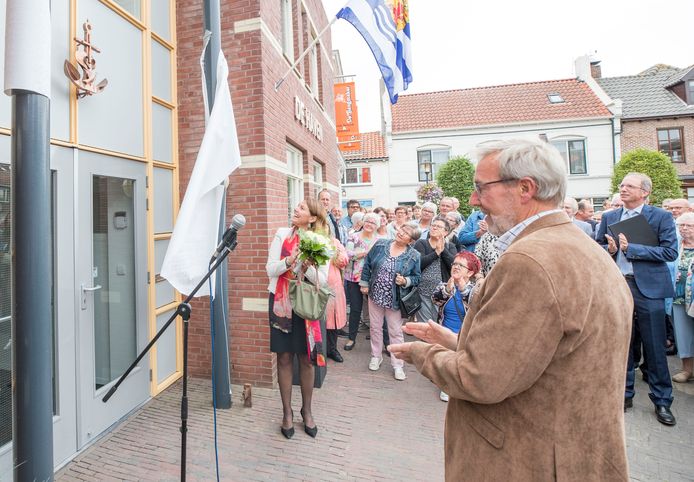Burgemeester José van Egmond heeft zojuist het beeldwerk ''Geloof Hoop en Liefde" onthuld boven de deur van het kerkelijk centrum "De Haven".