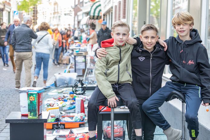 Pim, Luuk en Joep (vlnr) verkopen hun spullen op de Steenbergsestraat.