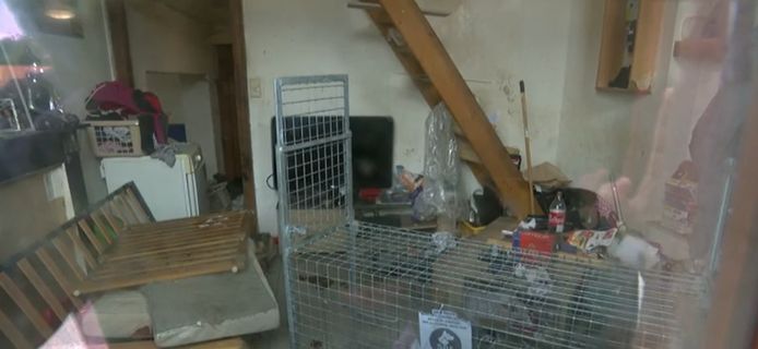 De woonkamer van het bescheiden huis, gefilmd door het raam.