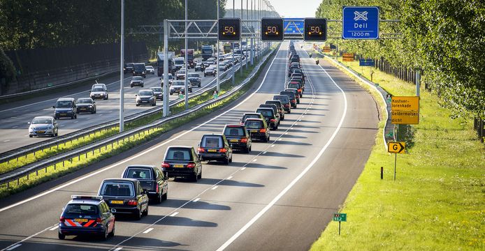 De colonne met lijkwagens passeert. In totaal 40 lijkwagens met een politie-escorte brengen de kisten vanaf Eindhoven naar Hilversum over de snelwegen A2 en A27.