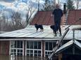 Een man op het dak van zijn overstroomde huis in Orenburg, Rusland (13 april 2024).