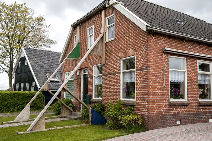 Een beschadigde woning wordt versterkt door stutten in aardbevingsgebied Loppersum