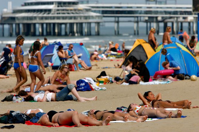 Strandgangers in Scheveningen, met achter de bekende Pier.