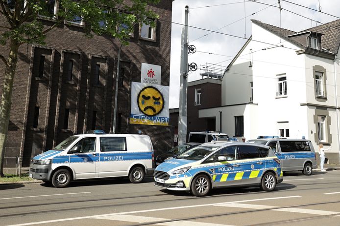 Politievoertuigen staan voor de geviseerde school in Essen.