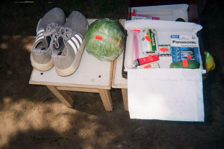 ‘Ik verzamel de hulpgoederen en verkoop ze in onze tuin. Mama heeft een kool gekocht, opa een aansteker. De sneakers zijn voor mijn papa, omdat hij niks had om aan zijn voeten te doen – de Russen hebben alles meegenomen. Ik heb ongeveer 250 Oekraïense grivna verdiend.’ Beeld Masha, 10 y.o