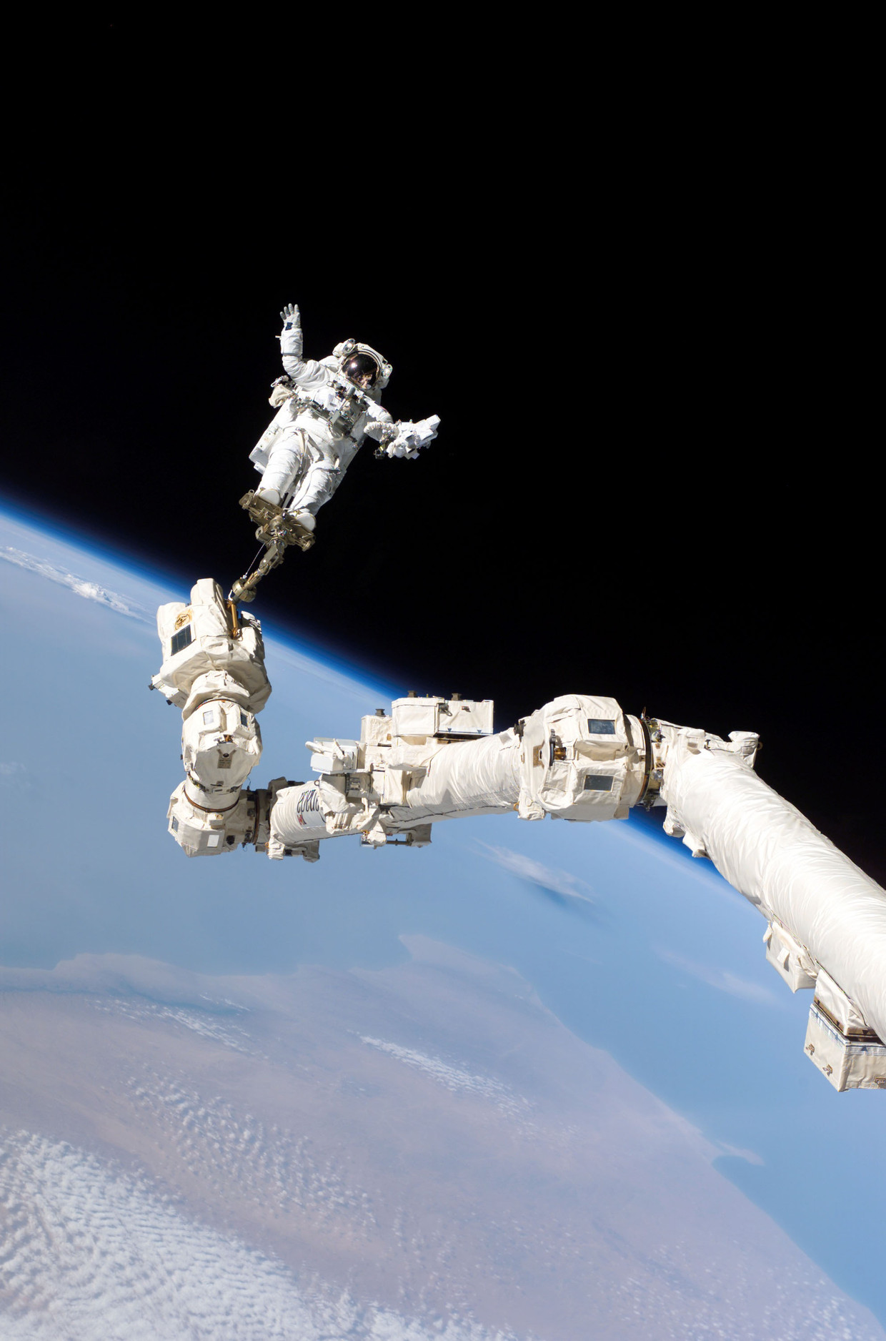 Astronaut Stephen K. Robinson is gekoppeld aan de robotarm van het ISS om een reparatie te doen aan de Discovery-shuttle, augustus 2005. Beeld Getty Images