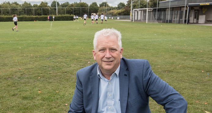 MULO-voorzitter Arjen Vos op sportpark De Braak in Helmond. Op de achtergrond de sportende leerlingen van het Dr. Knippenbergcollege.