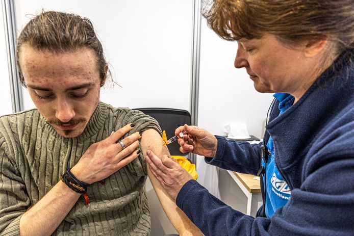 Een GGD-medewerkster zet een spuit in de arm van Pepijn Schokker. Hij was maandag een van de meer dan 850 jongeren die een HPV-vaccin kwam halen.