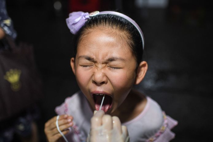 Een meisje wordt getest op het coronavirus in de stad Wuhan, de Chinese stad die geldt als de oorspronkelijke brandhaard van de pandemie.
