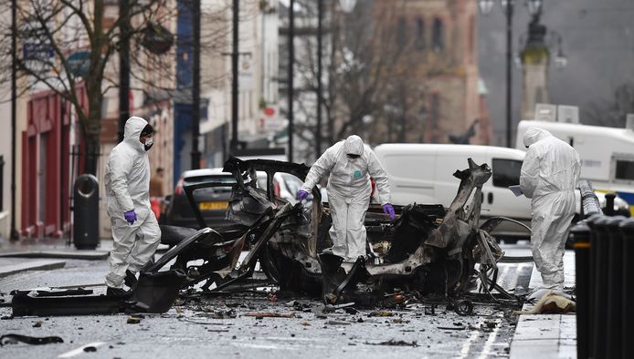Forensisch rechercheurs onderzoeken de wrakstukken van een busje dat als autobom is gebruikt bij een aanslag op de rechtbank in Derry.