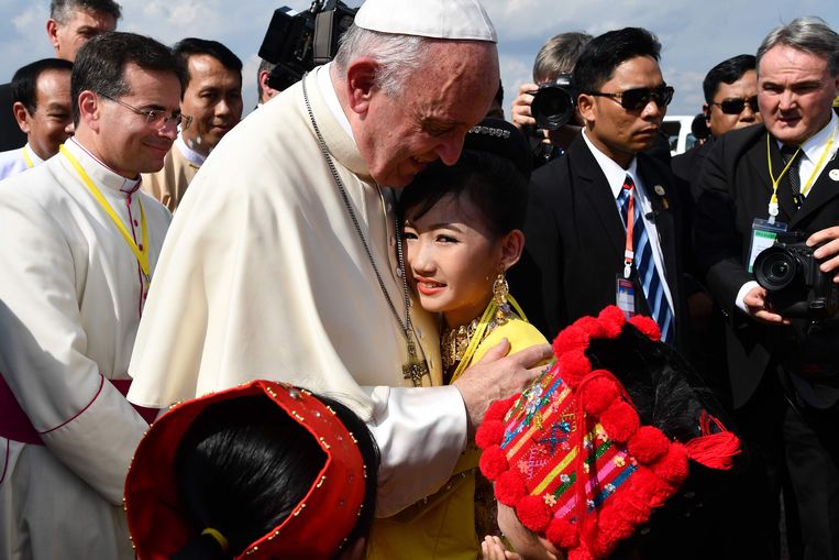 Paus Franciscus wordt begroet door kinderen in traditionele kledij na zijn aankomst vandaag in Yangon, Burma. Hij zal vier dagen in het land verblijven.  Beeld AFP