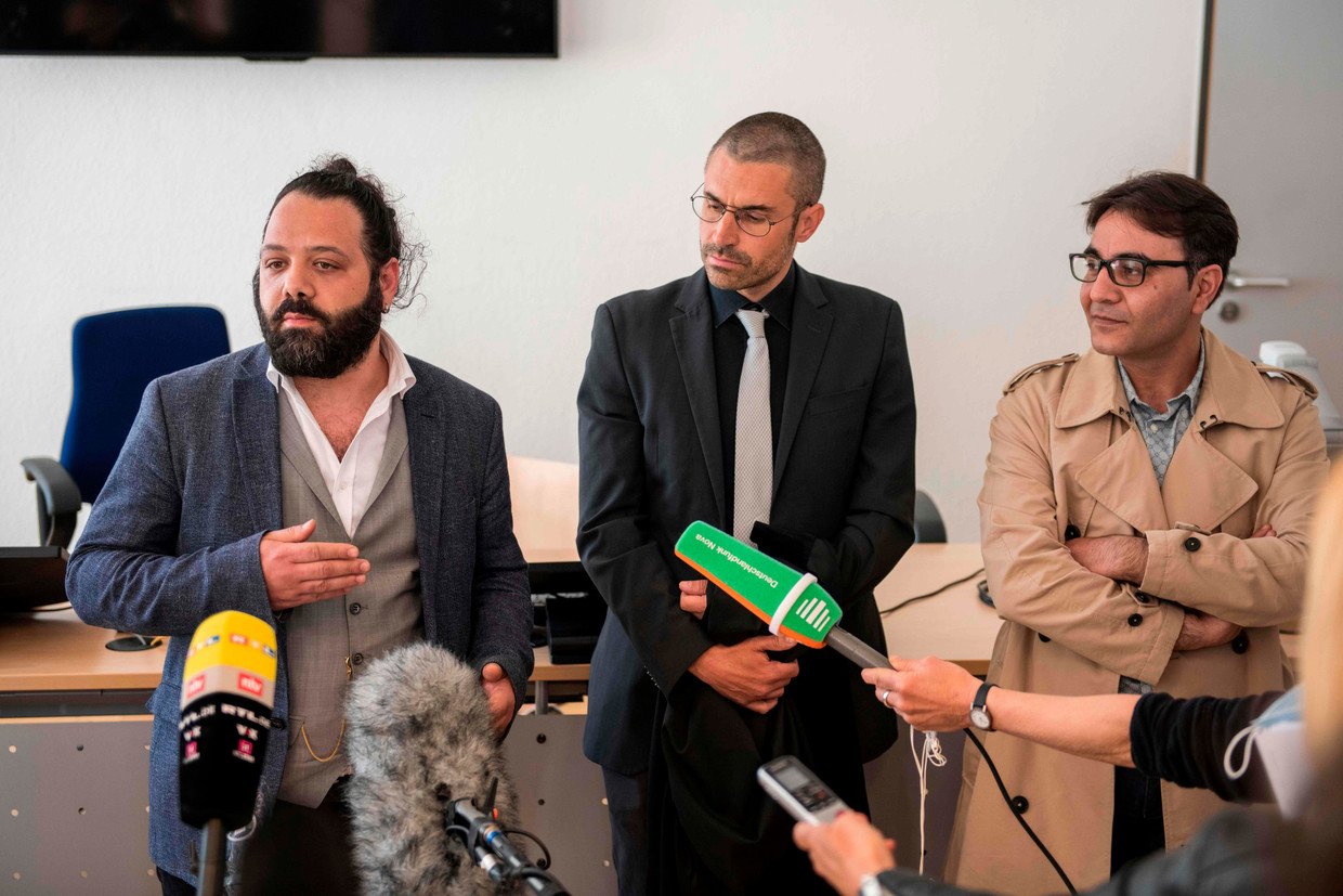 Advocaat Patrick Kroker (C) en mede-aanklagers Wassim Mukdad (L) en Hussein Ghrer (R) beantwoorden vragen van journalisten buiten de rechtszaal tijdens een pauze in een proces tegen twee Syrische beklaagden die worden beschuldigd van door de staat gesponsorde marteling in Syrië, afgelopen 23 april , 2020 in Koblenz, West-Duitsland. Beeld AFP