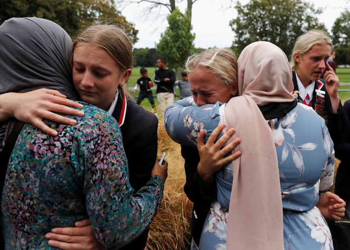 Leerlingen van een middelbare school in Christchurch omhelzen familieleden van slachtoffers die op nieuws over hun dierbaren wachten aan een gemeenschapscentrum in Christchurch.
