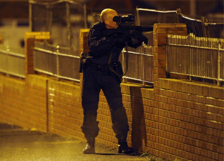 Een politieman staat op scherp in Craigavon, nadat een agent is neergeschoten. Foto AP/Peter Morrison Beeld 