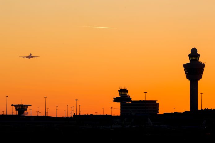 Amsterdam-Schiphol airport sunset  at a clear sky with departing airplane