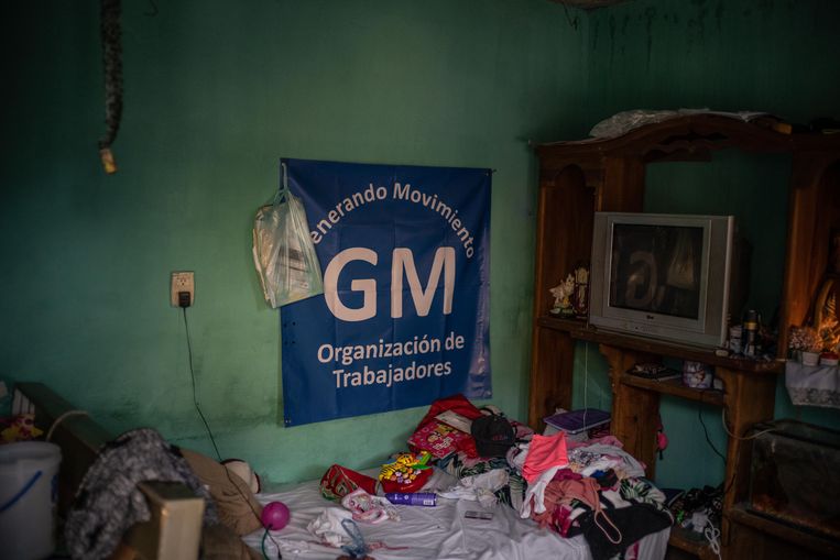 De kleine woning van Israel Cervantes, bezaaid met kleren en speelgoed. Aan de muur hangt de vlag van de onafhankelijke vakbond Generando Movimiento, die vooralsnog geen vuist kan maken. Beeld Volkskrant
